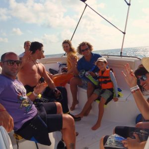 Pessoas num barco a caminho de nadar com um tubarão-baleia em mar aberto.