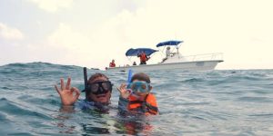 Pessoas com snorkel na superfície do mar, flutuando e observando o fundo marinho.