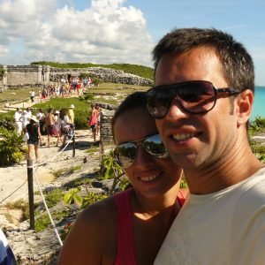 Casal tirando selfie nas ruínas de Tulum com o mar ao fundo