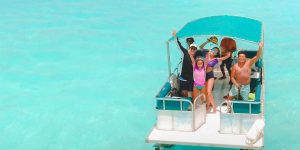 Pessoas a relaxar num barco na lagoa de Bacalar, rodeadas por águas azul-turquesa.