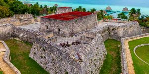 Forte de Forte de San Felipe Bacalar junto à lagoa, com arquitetura histórica e vista para águas turquesa.