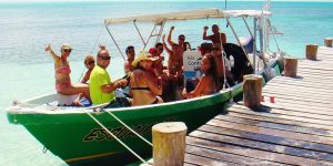 Pessoas felizes numa lancha em Isla Contoy, rodeadas por águas turquesa do Caribe.