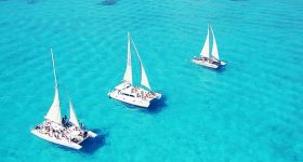 Três catamarãs em Isla Mujeres México no mar azul-turquesa do Caribe