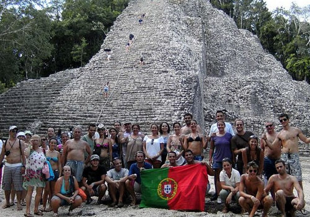 Turista com bandeira de Portugal em Ruínas de Cobá durante Excursão Coba com Exploratours